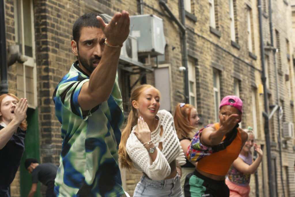 Group of mixed young people dancing in front of historic buildings