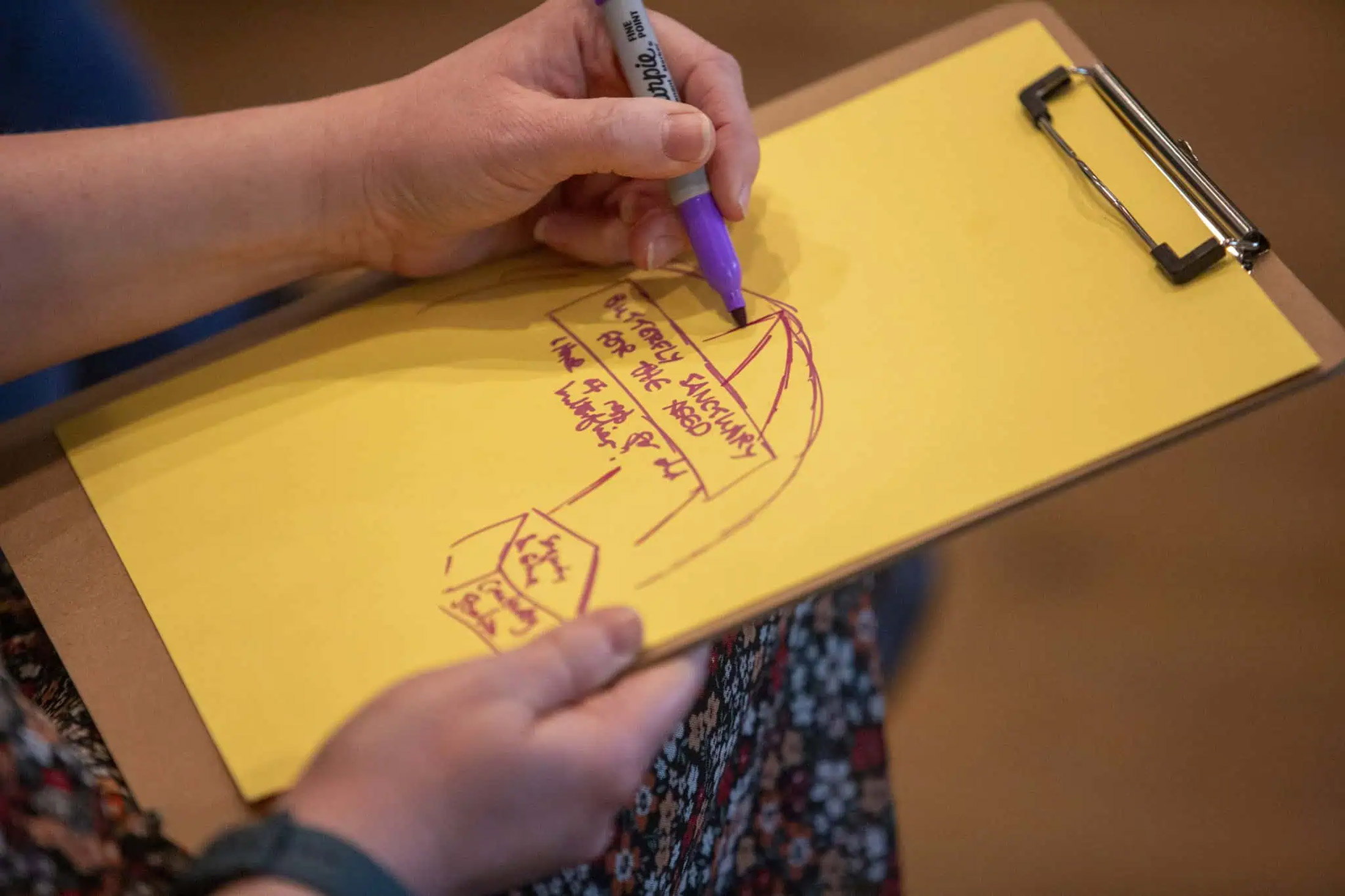 Drawing in red ink on a clipboard