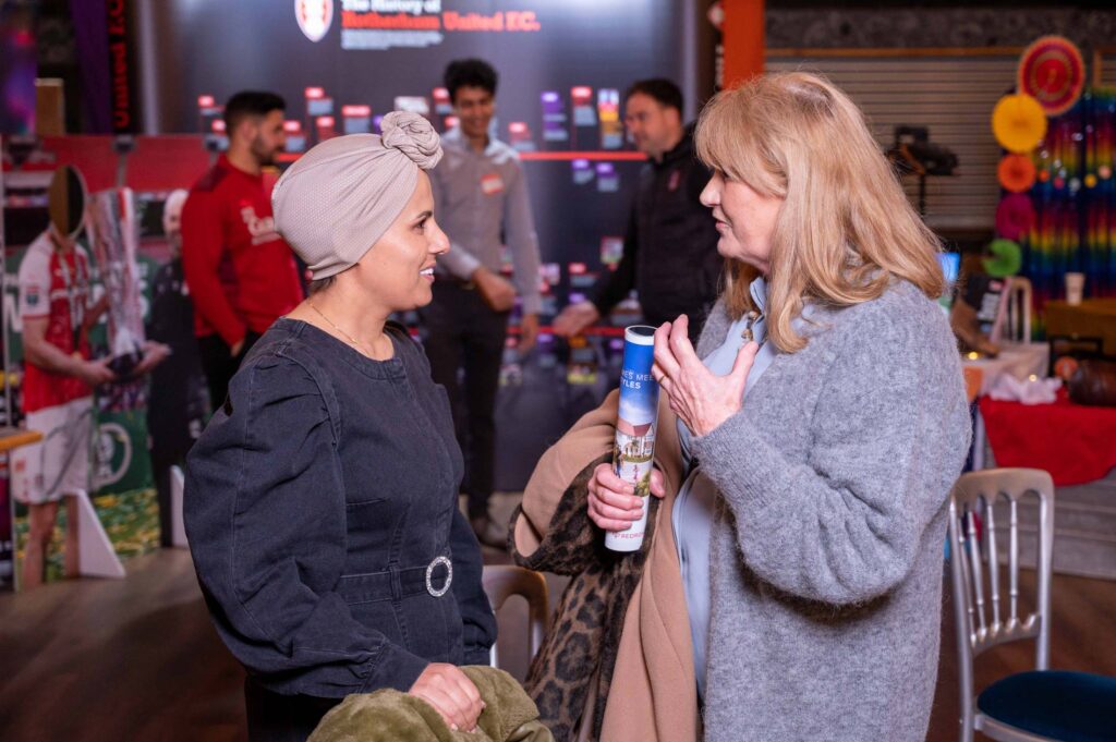 Two women talking and smiling at a conference