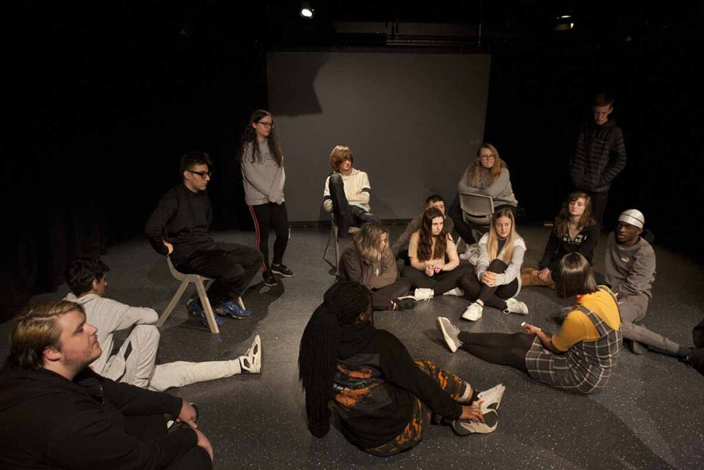 Group of young people sitting on the floor having a discussion