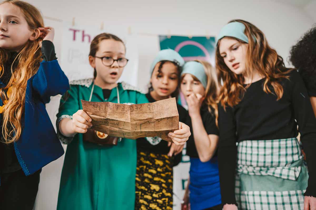 Five school girls taking part in a drama performance